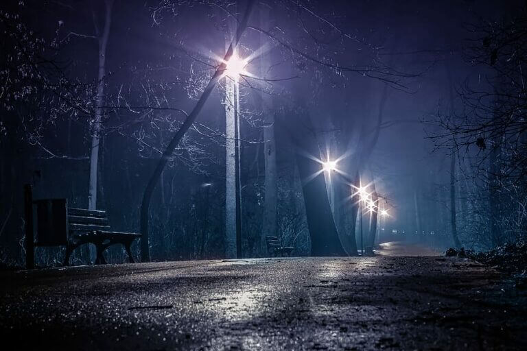 Park trail at night lit by street lamps