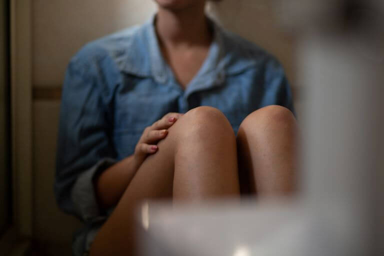 Girl sitting on floor against wall